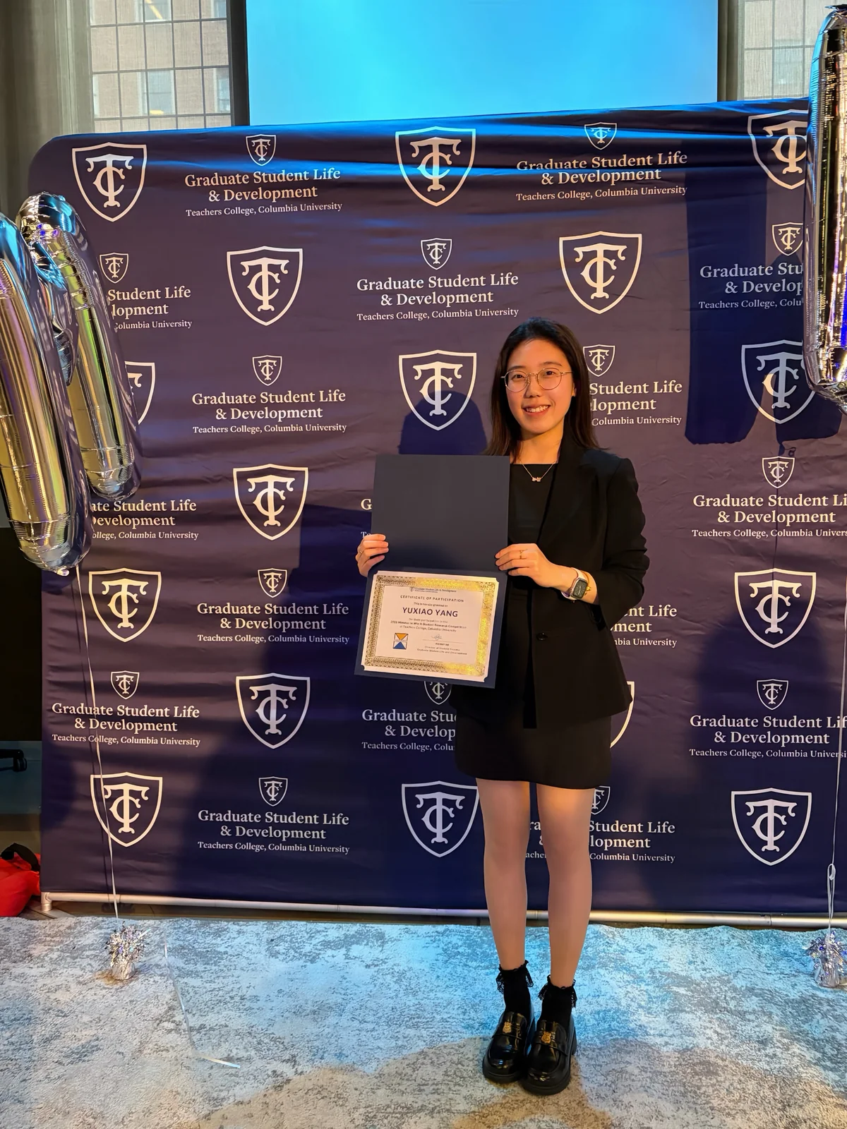 Xiao Yang holding her finalist certificate at the Teachers College 3MT event