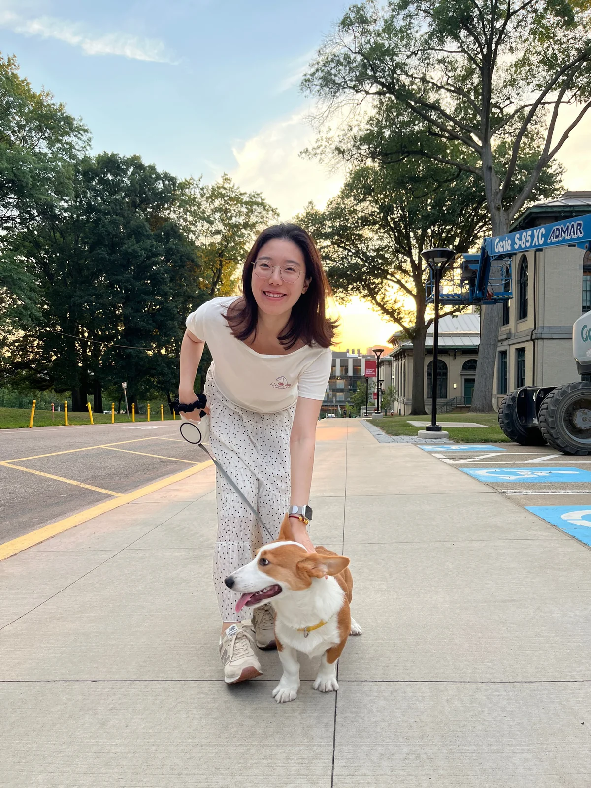 Xiao Yang outdoors with a corgi